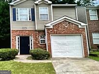 Charming two-story home with brick accents and a well-manicured front yard at 5057 Windsor Forrest Lane, Atlanta, GA 30349