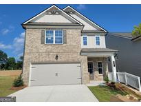 New construction two-story home featuring a two-car garage, gray brick, and gray vinyl siding at 35 Fraser Ln # 123B, Auburn, GA 30011