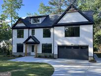 Beautiful two-story white brick home with a black roof, black trim, and a two-car garage at 4955 Chamblee Dunwoody Rd, Dunwoody, GA 30338