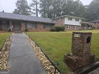 Charming single-story home with a well-manicured lawn and welcoming walkway at 1110 Hilburn Se Dr, Atlanta, GA 30316
