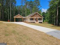 Charming single-story home featuring a welcoming front porch, carport, and a well-maintained yard with beautiful curb appeal at 55 Etheridge Rd, Temple, GA 30179