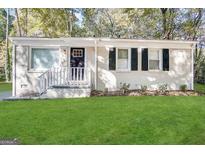 Charming single-story home with white brick, black shutters, manicured lawn, and a welcoming front entrance at 914 Mercury Nw Dr, Atlanta, GA 30331