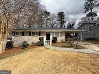 Charming single-story home with a brick facade, well-maintained front yard, and a convenient covered carport at 1068 Longshore Dr, Decatur, GA 30032