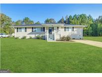 Charming single-story home with a well-manicured lawn, inviting front porch, and freshly painted trim at 64 Gregory Ct, Dallas, GA 30157