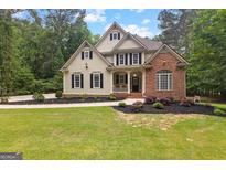 Charming two-story home with a manicured lawn and inviting curb appeal with mature trees at 155 Carrolls Way, Fayetteville, GA 30215