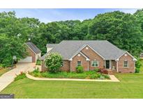 A beautiful, single-story brick house with lush landscaping and a well-manicured lawn at 344 Mckibben Dr, Locust Grove, GA 30248