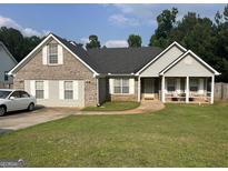 Charming single-Gathering home with well-manicured lawn, inviting front porch, and traditional brick and siding exterior at 740 Pebble Blvd, Covington, GA 30016