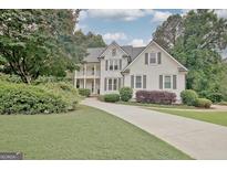 Charming two-story home with a well-manicured lawn and beautiful landscaping at 505 Lighthouse Ln, Peachtree City, GA 30269