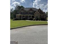 Inviting two-story home with a manicured lawn, traditional architectural details, and a welcoming front porch at 121 Fountain Oak, Villa Rica, GA 30180