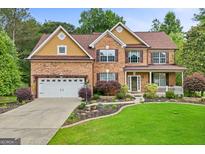 Charming two-story brick home with a well-manicured lawn, attached garage, and inviting front porch at 52 Olivia Ct, Palmetto, GA 30268