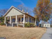 Charming traditional home featuring a front porch with swing and a well-maintained lawn at 5143 Floyd Ne St, Covington, GA 30014
