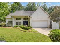 Charming single-story stucco home with lush front yard and attached two-car garage at 111 Kenton Pl, Peachtree City, GA 30269
