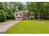 Charming two-story home featuring a brick facade, attached two-car garage, and a lush green lawn at 129 Onyx Ct, Carrollton, GA 30116