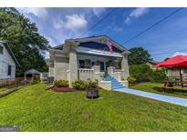 Charming home boasts a covered front porch, brick accents, and a vibrant blue pathway at 1091 Selwin Sw Ave, Atlanta, GA 30310