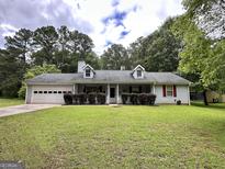 Charming one-story home with attached garage and well-manicured lawn at 150 Willow Shoals Dr, Covington, GA 30016