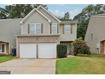 Charming two-story home with a two-car garage, neutral siding and brick accents, complimented by mature landscaping at 7813 Newbury Dr, Jonesboro, GA 30236