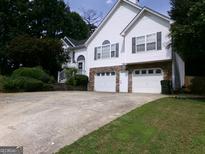 Charming two-story home featuring a 2-car garage, stone accents, and a well-maintained lawn at 49 Brinkley Ct, Dallas, GA 30157
