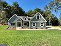 Charming new construction home with well-maintained lawn, gray siding, and inviting entrance at 296 Deer Creek Run # 11, Moreland, GA 30259