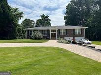 Charming brick home with a well-manicured lawn and a convenient two-car garage at 3962 Chicamauga Ne Dr, Kennesaw, GA 30144