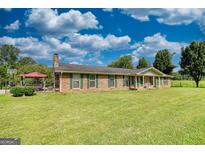 Charming single-story brick home with green shutters and a well-manicured lawn at 12621 Highway 142, Oxford, GA 30054