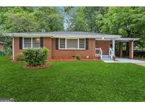 Charming brick home with a well-maintained lawn, covered carport, and traditional windows at 2858 Valley Ridge Dr, Decatur, GA 30032