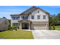 Charming two-story home featuring a spacious two-car garage, complemented by a well-manicured lawn and inviting entrance at 3005 Nicholas Dr, Villa Rica, GA 30180
