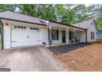 Charming single-story home featuring a one-car garage and inviting front porch with rocking chairs at 2038 Summertown Dr, Norcross, GA 30071