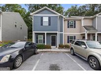 Two-story townhouse featuring a dark gray facade, black door, and adjacent parking at 2137 Chadwick Sw Rd, Atlanta, GA 30331