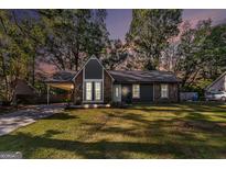 Charming home featuring stone accents, a covered carport, a well-manicured lawn, and tasteful landscaping at 113 Caldwell Dr, Hampton, GA 30228