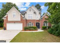 Charming two-story brick home with a manicured lawn and attached two-car garage at 1602 Cascade Overlook, Peachtree City, GA 30269