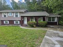 Charming split-level home with brick accents, arched porch, and well-maintained front lawn at 2670 Foxlair Trl, South Fulton, GA 30349