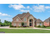Stunning brick home with manicured lawn and circular driveway, exuding curb appeal and charm at 413 Canterbury Way, Jonesboro, GA 30236