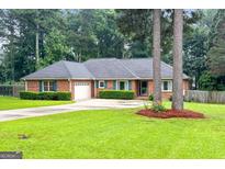 Charming brick home with a well-manicured lawn and inviting curb appeal at 7972 Woods Lane, Jonesboro, GA 30236