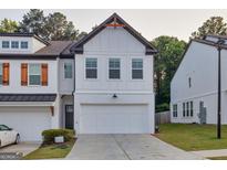 Charming two-story home showcasing white siding, a two-car garage, and a well-maintained lawn at 375 Auburn Valley Way, Auburn, GA 30011