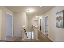 Bright hallway featuring neutral paint, carpet flooring, and an open staircase to the lower level at 2276 Waycross Ln # 21, Dacula, GA 30019