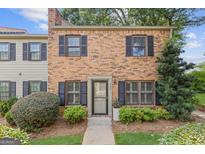 Charming brick townhome with well-maintained landscaping and black shutters on windows at 242 Adair St, Decatur, GA 30030