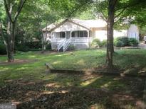 Charming home with a spacious front yard and a covered porch at 304 Tunis Rd, Mcdonough, GA 30253