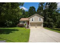 Charming two-story home features a well-maintained lawn, two-car garage, and inviting red front door at 177 Rustin Dr, Dallas, GA 30157