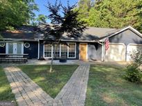Charming home with a manicured front yard and a welcoming entrance and garage at 211 Groveland Dr, Peachtree City, GA 30269