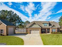 Charming brick home with a well-manicured lawn and attached two car garage and a detached one car garage at 125 Kayla Ct, Locust Grove, GA 30248