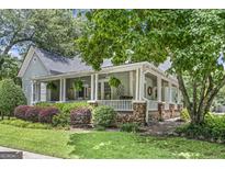 Charming home boasts a large, inviting wraparound porch and beautiful landscaping at 3119 Conyers Se St, Covington, GA 30014