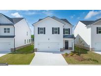 Two-story home featuring white siding, black shutters, a two-car garage, and a well-manicured lawn at 11884 Aukerman Way, Hampton, GA 30228