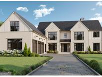 Stunning two-story home with a three car garage, a manicured lawn, and beautiful flowers lining the driveway at 4360 Riverstone Shls, Ellenwood, GA 30294