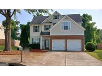 Charming two-story home with a brick-accented two-car garage and well-maintained landscaping at 7069 Littlebrook Way, Douglasville, GA 30134