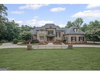 Stately brick home with a manicured lawn, mature landscaping, and classic architectural details at 1385 Gordon Rd, Moreland, GA 30259