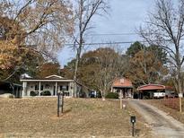 Street view of two homes on a treed lot with driveway and signage at 10142 Washington Street, Covington, GA 30014