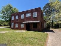 Two-story brick building with a dark awning shading the front entrance at 889 W Hightower Trail, Social Circle, GA 30025