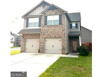 Charming two-story home featuring a brick and siding facade, two-car garage, and a well-maintained lawn at 301 Leland Ct, Mcdonough, GA 30253