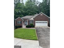 Charming single-story brick home featuring a two-car garage and well-maintained landscaping in a lush, green setting at 2074 Ayers Creek Ct, Villa Rica, GA 30180