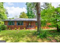Charming brick home featuring a manicured lawn, stylish shutters, and inviting front entrance at 3219 W Manor Ln, Atlanta, GA 30311
